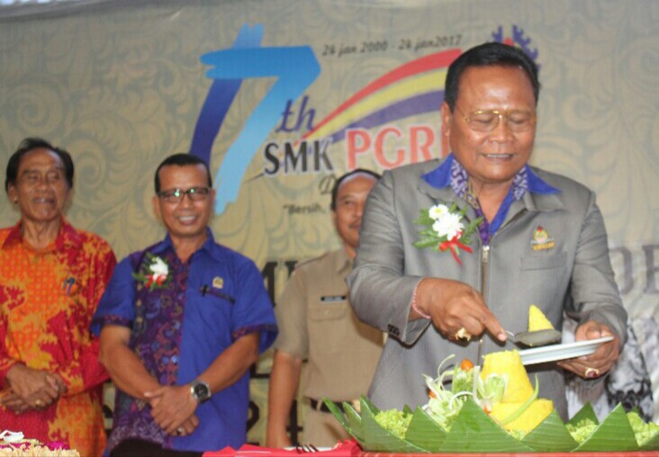 Drs. I Nengah Madiadnyana, MM., Kepala SMK PGRI 3 Denpasar memotong tumpeng dalam puncak HUT 17 Trigriska, foto;alt